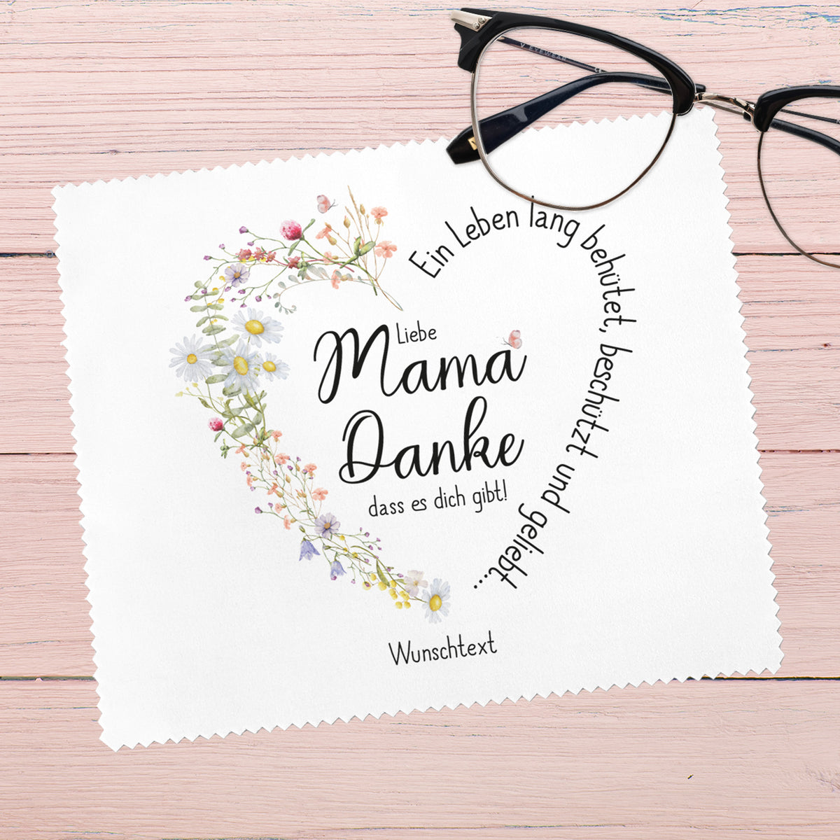 Brillenputztuch für Mama mit liebevoller Botschaft, auf hellem Holzuntergrund mit Brille als Dekoration.