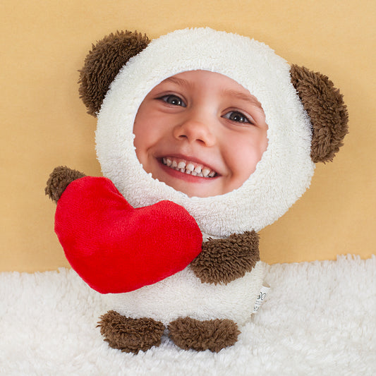 Fototeddy mit Kinderfoto als Gesicht und rotem Herz auf heller Kuscheldecke