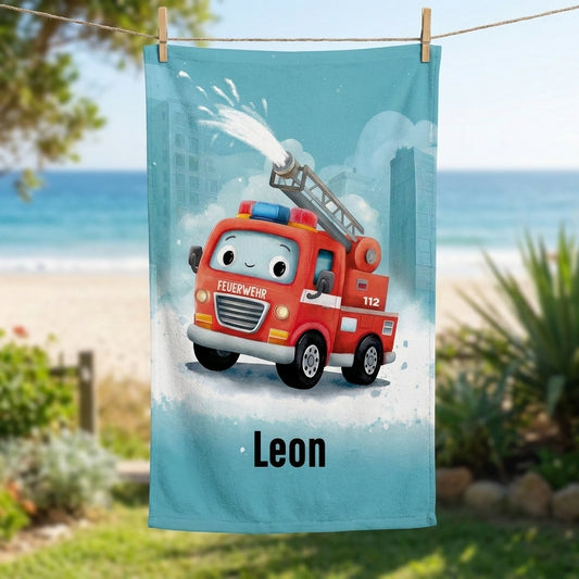 Feuerwehr Handtuch mit Name Leon, rotem Feuerwehrauto und türkisblauem Hintergrund an einer Wäscheleine am Strand