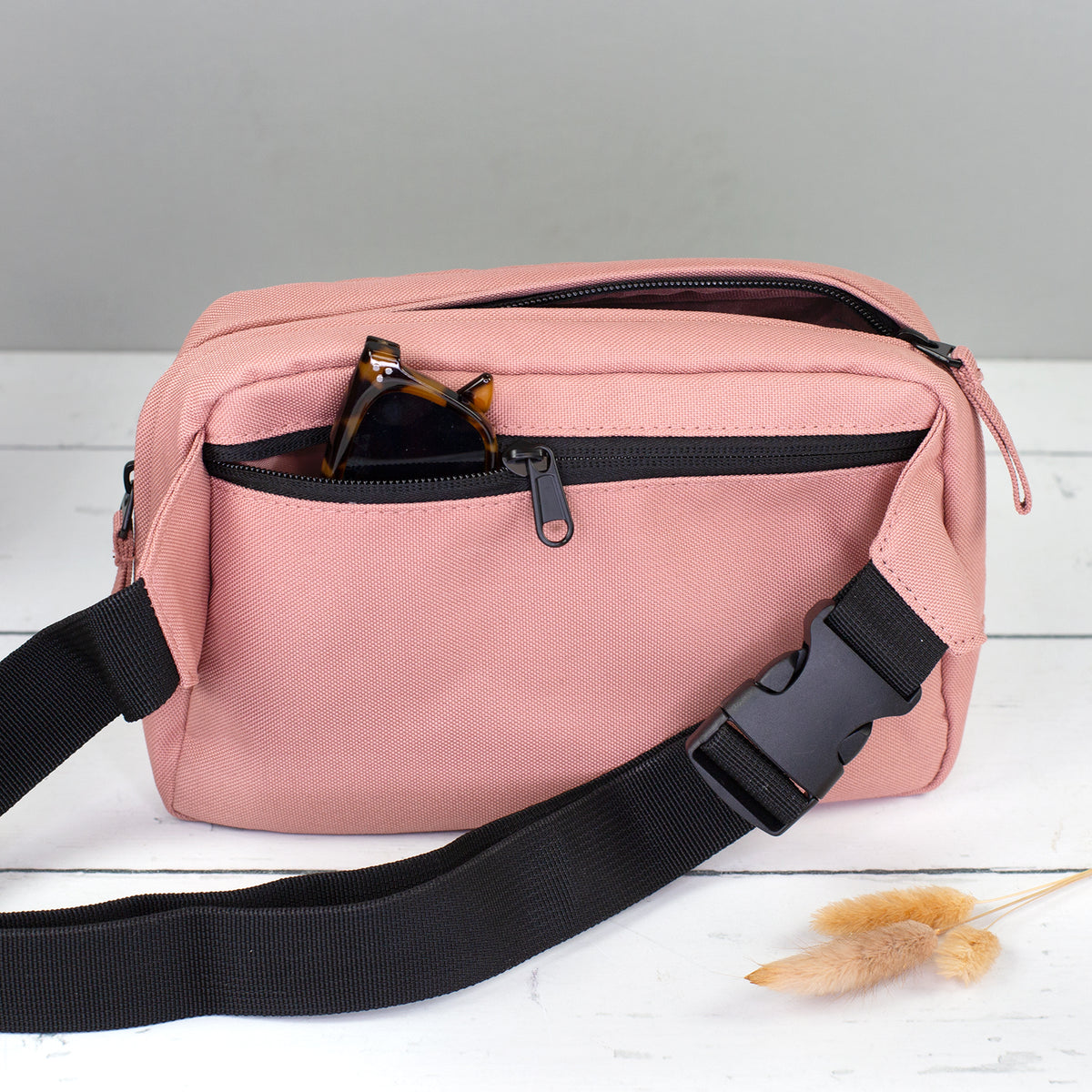 Rückseite der altrosa Bauchtasche mit Reißverschlussfach und Sonnenbrille