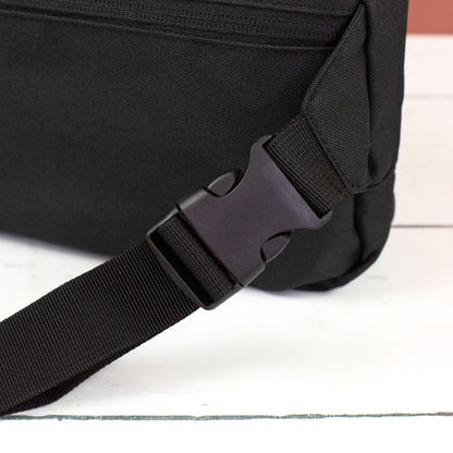 Detailansicht vom schwarzen Clipverschluss und verstellbarem Gurt der Bauchtasche