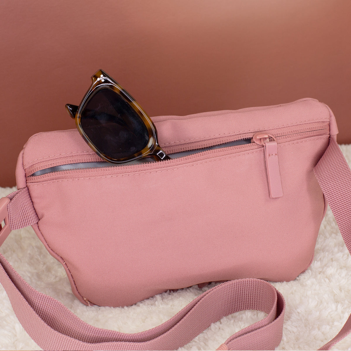 Rückseite der rosa Dog Mom Bauchtasche mit Reißverschlussfach und eingesteckter Sonnenbrille