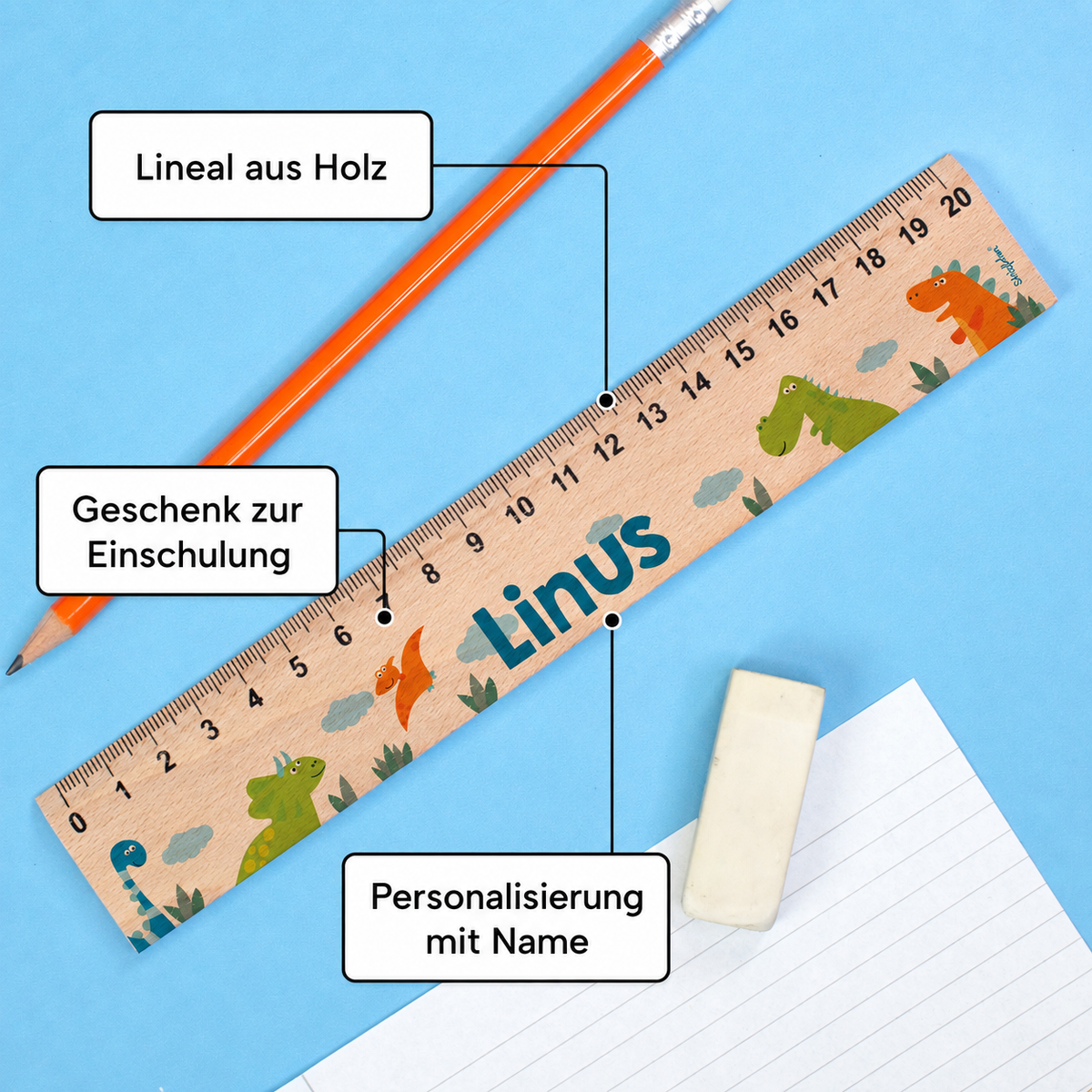 Personalisiertes Dino-Lineal aus Holz mit Name Linus auf blauem Hintergrund mit Stift und Radiergummi