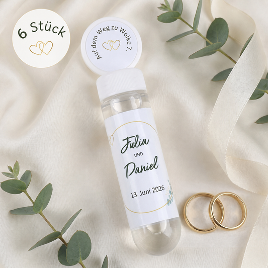Personalisierte Seifenblasen zur Hochzeit mit Namen Julia und Daniel neben Eukalyptus und Ringen
