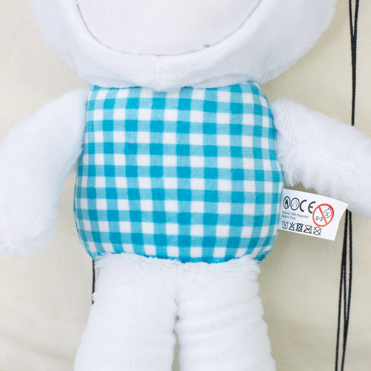 Detailaufnahme des blau karierten Stoffkörpers am Kuscheltier Hase