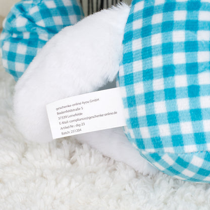 Detailaufnahme vom Herstelleretikett am blauen Kuscheltier Hase mit Fotogesicht