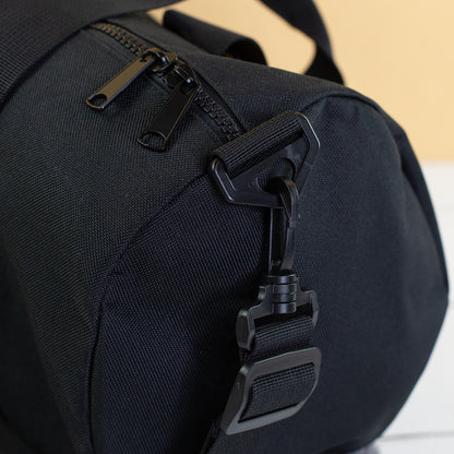 Detailaufnahme von Schultergurt, Karabiner und Reißverschluss der Sporttasche