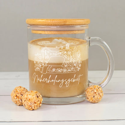 Glastasse mit Latte, Bambusdeckel und weißem Nähmaschinen-Motiv mit Blumen und Schriftzug „Näherholungsgebiet“
