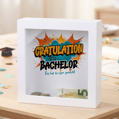Bilderrahmen-Spardose „Gratulation zum Bachelor“ mit Geldschein und Münzen hinter Glas