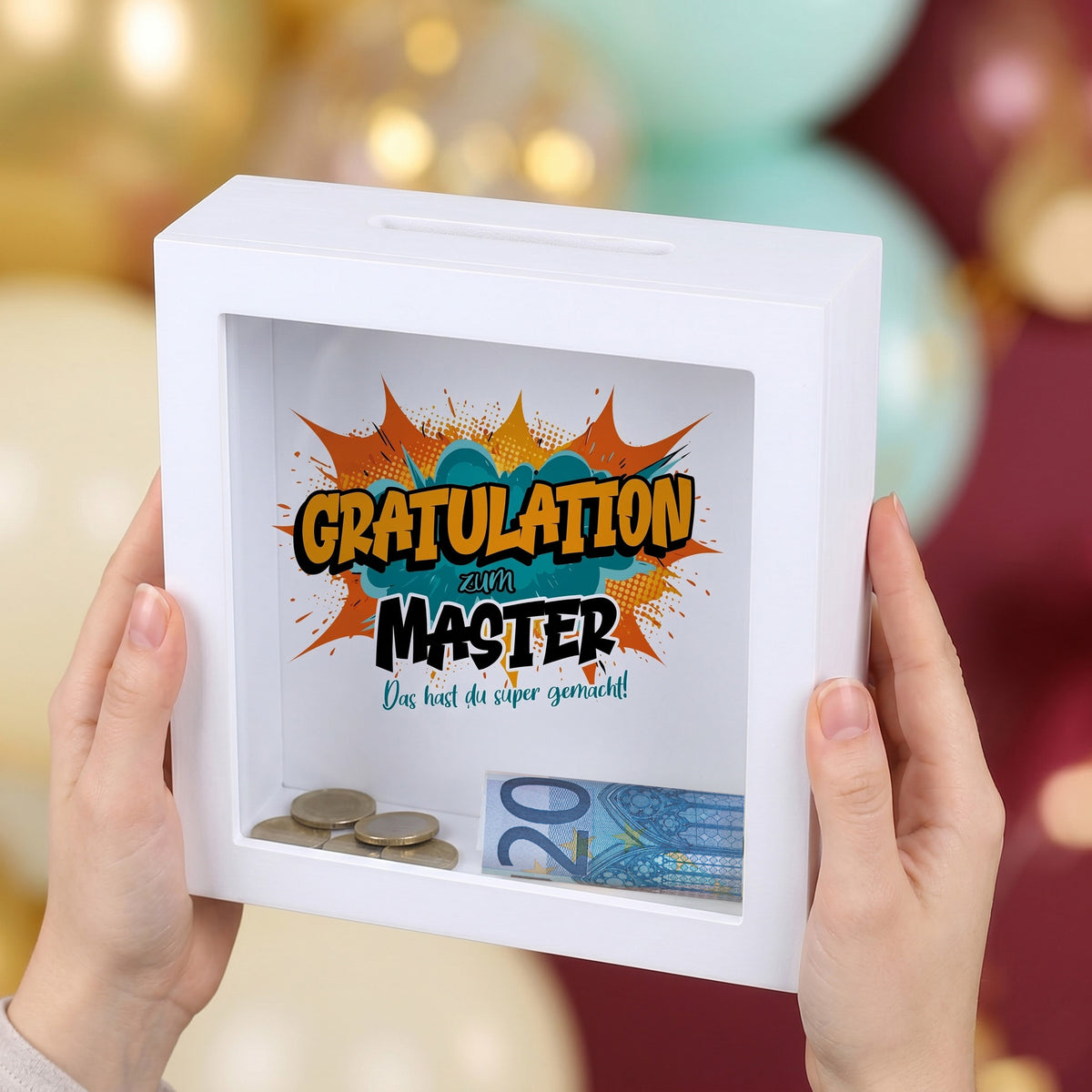 Geldgeschenk-Spardose „Gratulation zum Master“ im weißen Bilderrahmen auf festlicher Deko
