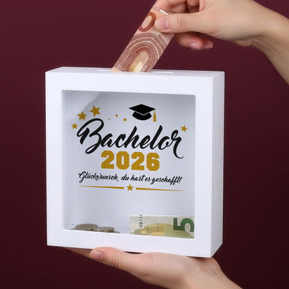 Bilderrahmen-Spardose „Bachelor 2026“ mit Geldschein und Münzen hinter Glas