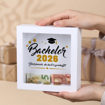 Bilderrahmen-Spardose „Bachelor 2026“ mit Geldschein und Münzen hinter Glas