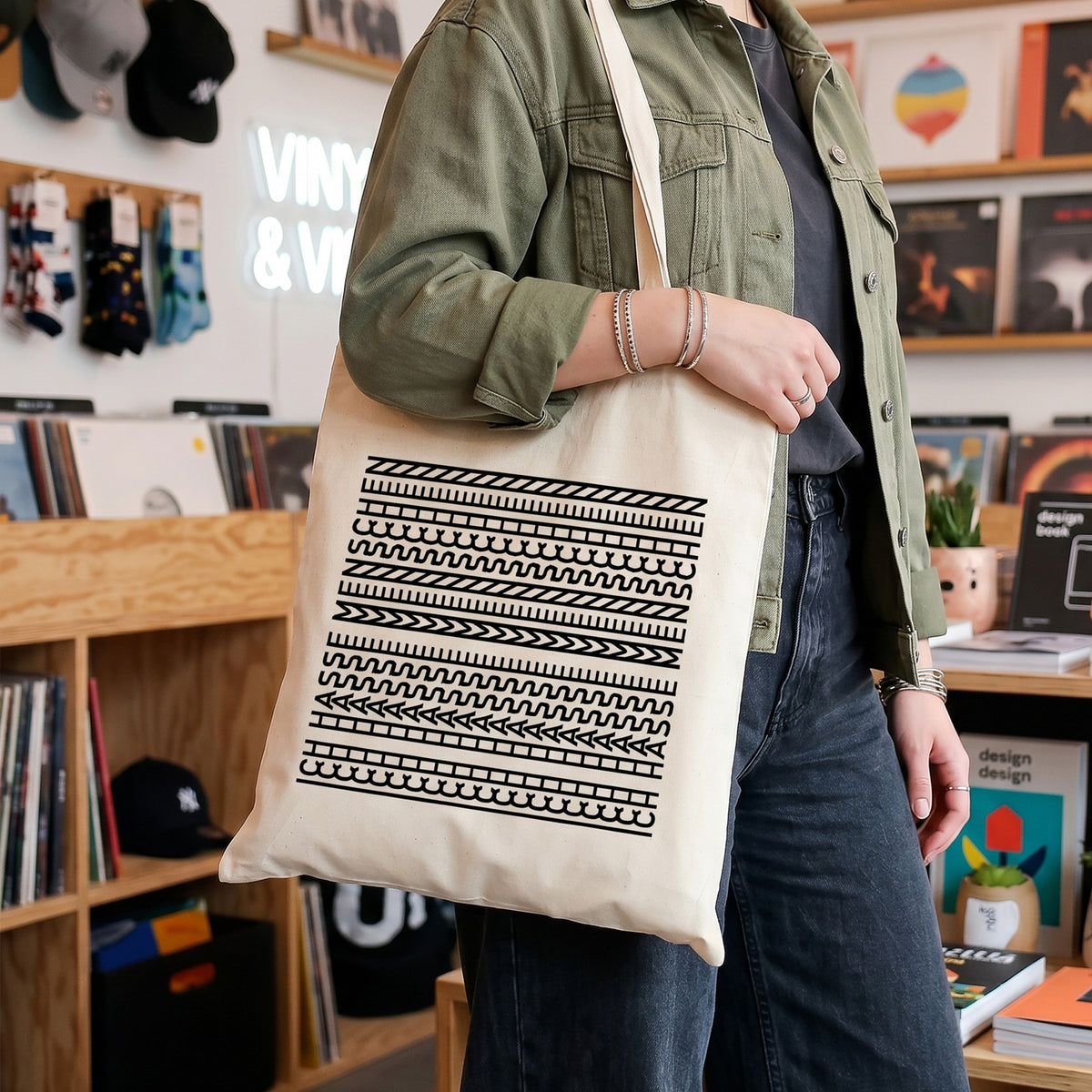 Baumwolltasche mit schwarzem Statement-Motiv „Ich hasse Menschen“ über der Schulter in einem Plattenladen