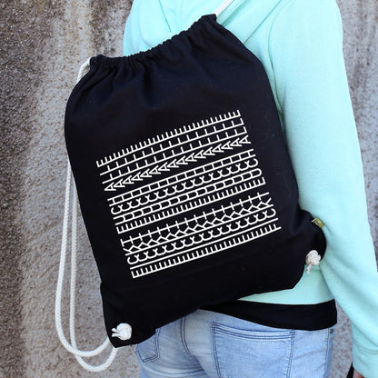 Schwarzer Stoffrucksack mit Naturkordeln und frechem weißen Statement-Motiv „F*ckt euch alle“ auf dem Rücken getragen