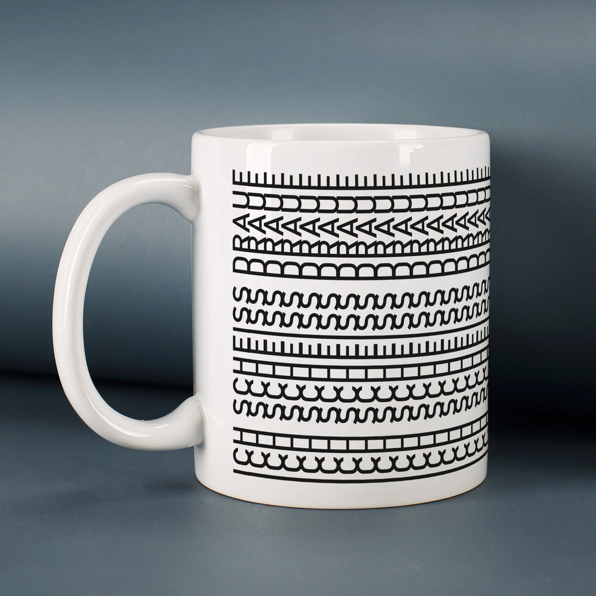 Lustige Tasse mit verstecktem Schriftzug vor dunklem Hintergrund