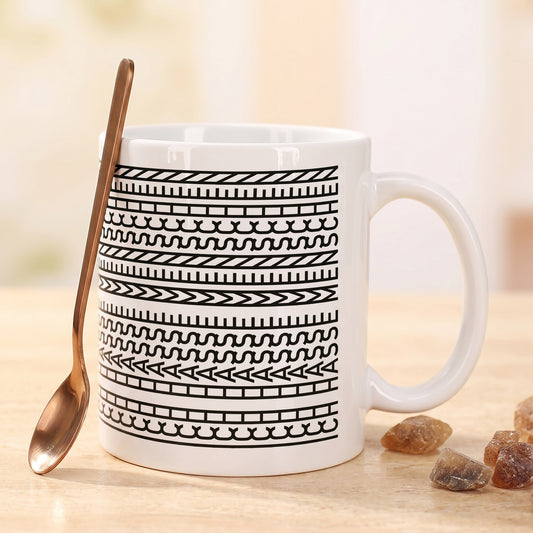 Weiße Tasse mit modernem Muster neben Löffel und Kandiszucker