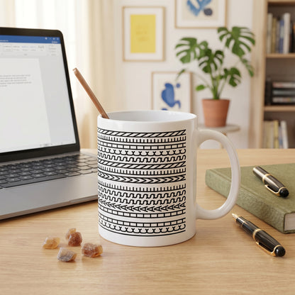 Lustige Keramiktasse mit verstecktem Schriftzug auf Schreibtisch neben Laptop und Notizbuch