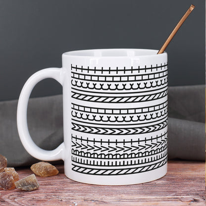 Keramiktasse mit modernem Muster auf rustikalem Holztisch mit einem Löffel innen