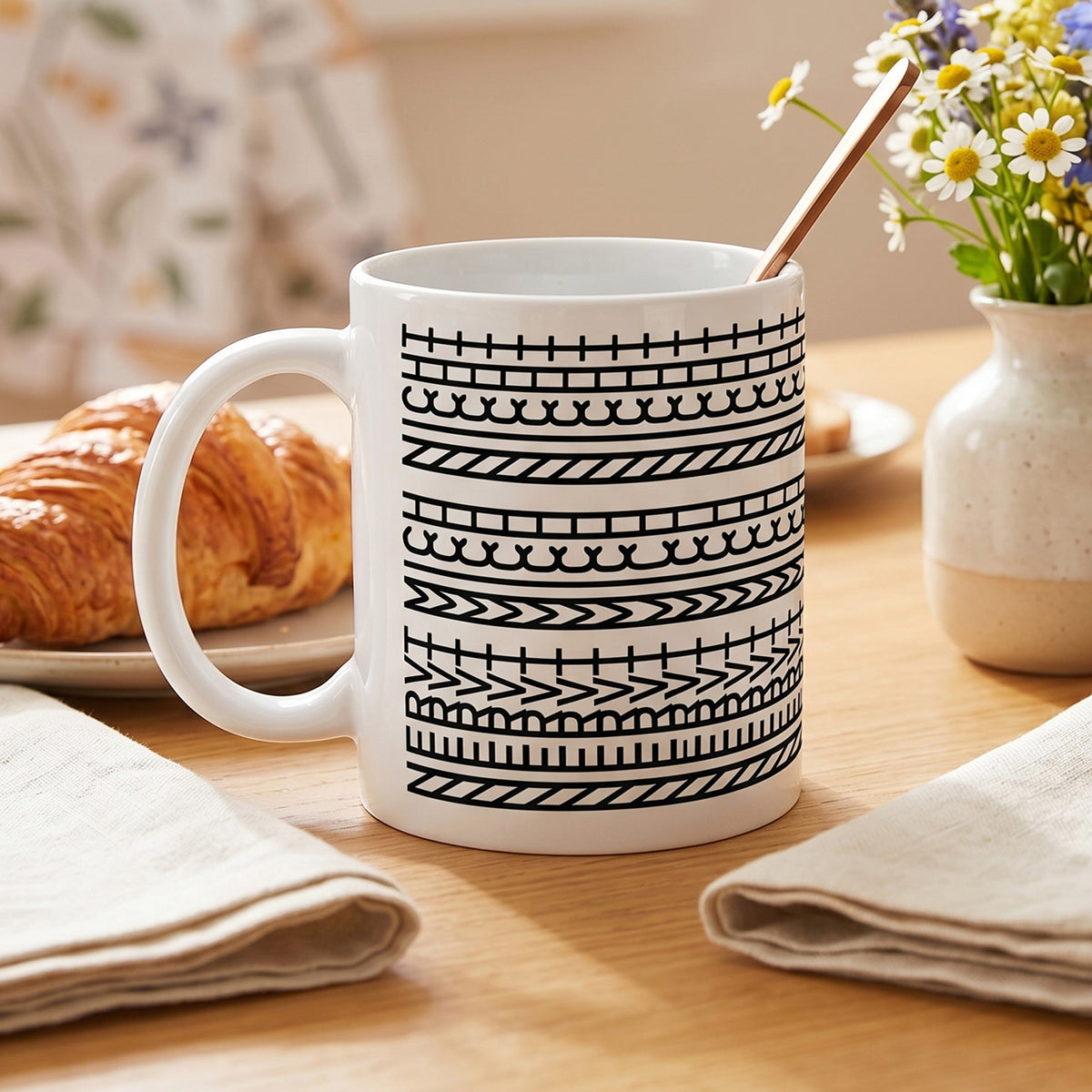 Bürotasse mit versteckter Botschaft auf einem Frühstückstisch mit Croissant