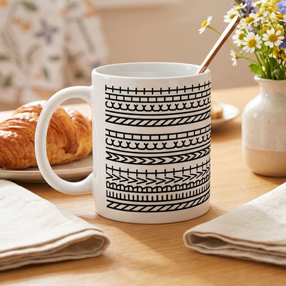 Bürotasse mit versteckter Botschaft auf einem Frühstückstisch mit Croissant