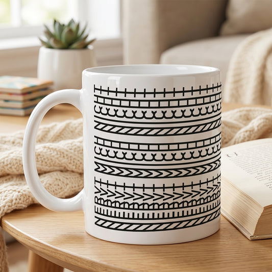 Weiße Keramiktasse mit modernem Schwarz-Weiß-Muster auf einem Wohnzimmertisch