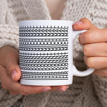 Lustige Tasse mit Schwarz-Weiß-Muster wird in beiden Händen gehalten