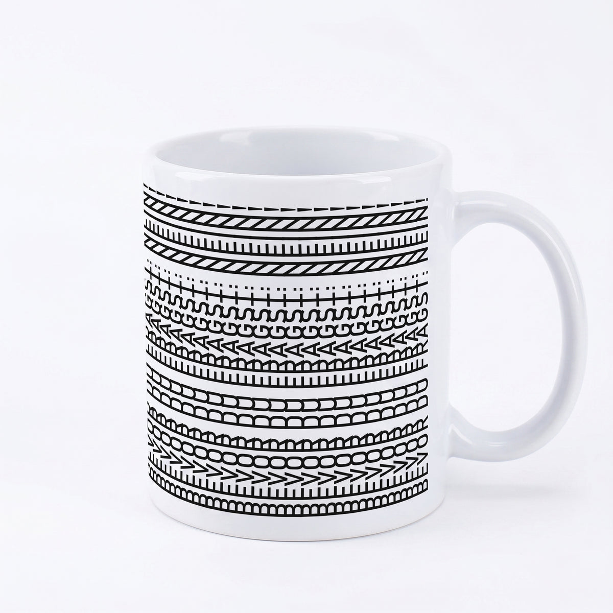 Keramiktasse mit schwarzem Linienmuster und verstecktem Spruch auf weißem Hintergrund