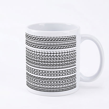Keramiktasse mit schwarzem Linienmuster und verstecktem Spruch auf weißem Hintergrund