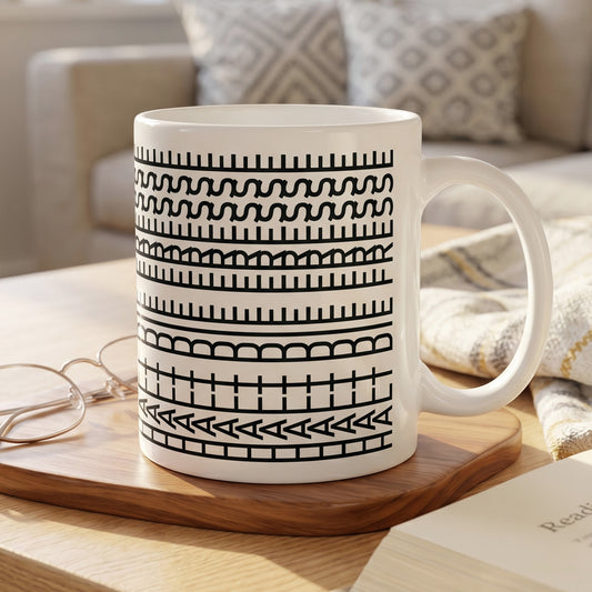 Kaffeetasse mit grafischem Schwarz-Weiß-Muster und verstecktem Spruch auf Holzbrett im gemütlichen Wohnambiente