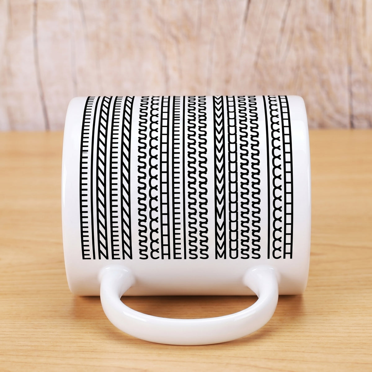 Kaffeetasse liegend mit Muster, in dem der Spruch „Einen Scheiss muss ich“ versteckt ist