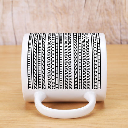 Kaffeetasse liegend mit Muster, in dem der Spruch „Einen Scheiss muss ich“ versteckt ist