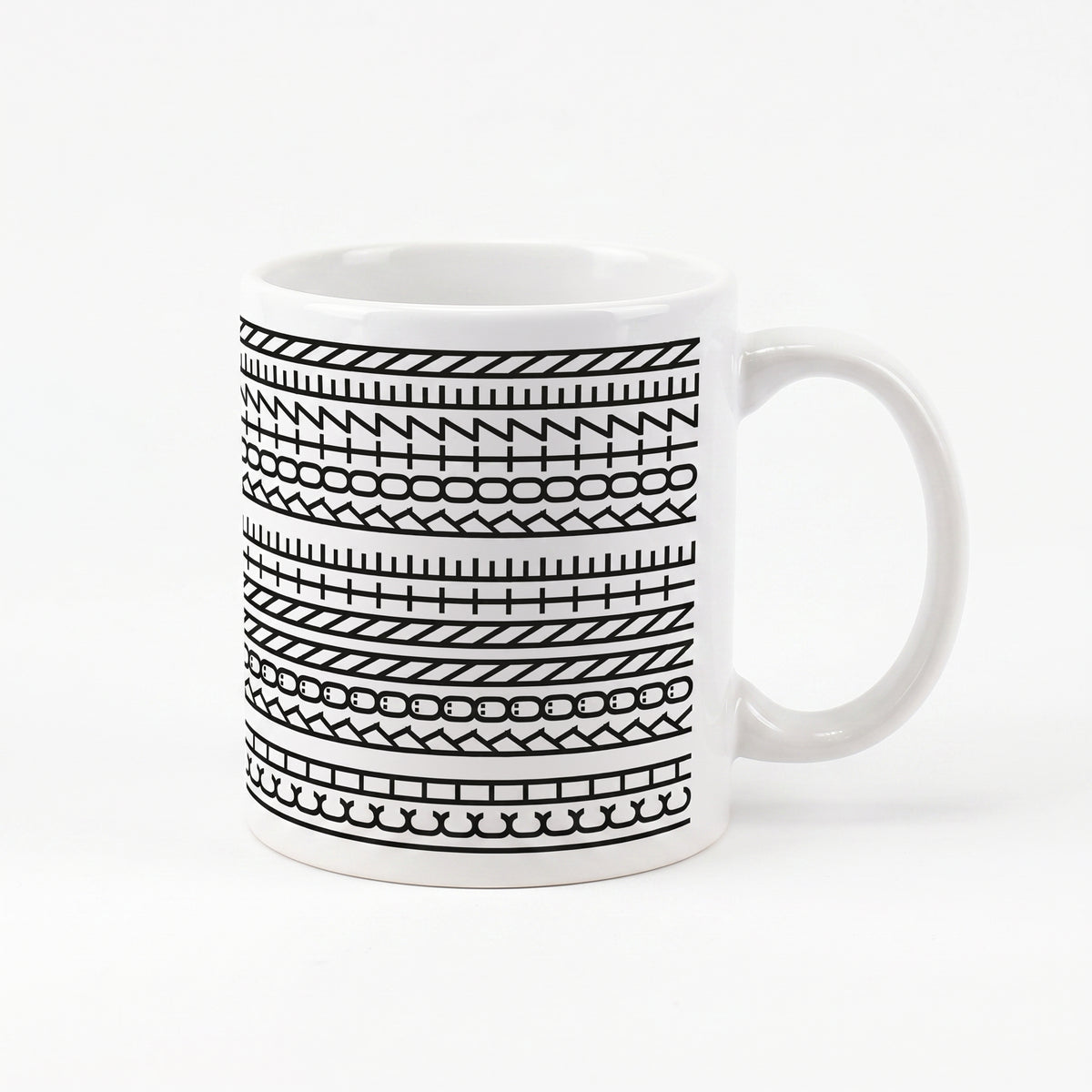 Kaffeetasse mit schwarzem Muster und versteckter Botschaft „Ich könnte kotzen“ auf weißem Hintergrund