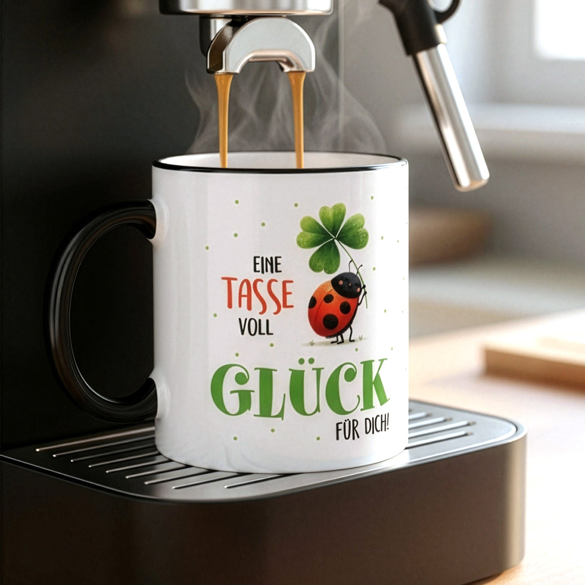 Tasse „Eine Tasse voll Glück“ unter Kaffeemaschine mit schwarzem Henkel