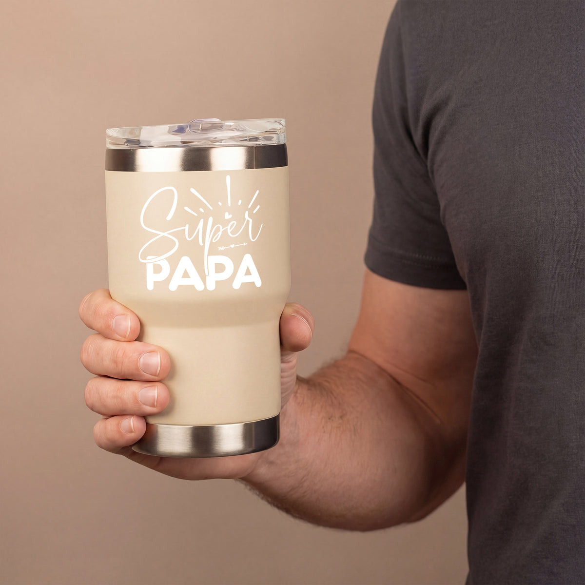 Beiger Thermobecher mit weißem Super Papa Schriftzug in der Hand eines Mannes