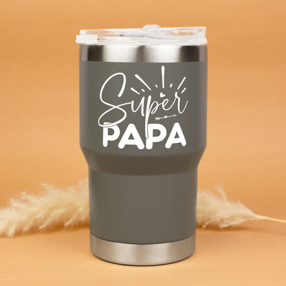 Grauer Thermobecher mit Super Papa Aufdruck freigestellt vor warmem Hintergrund