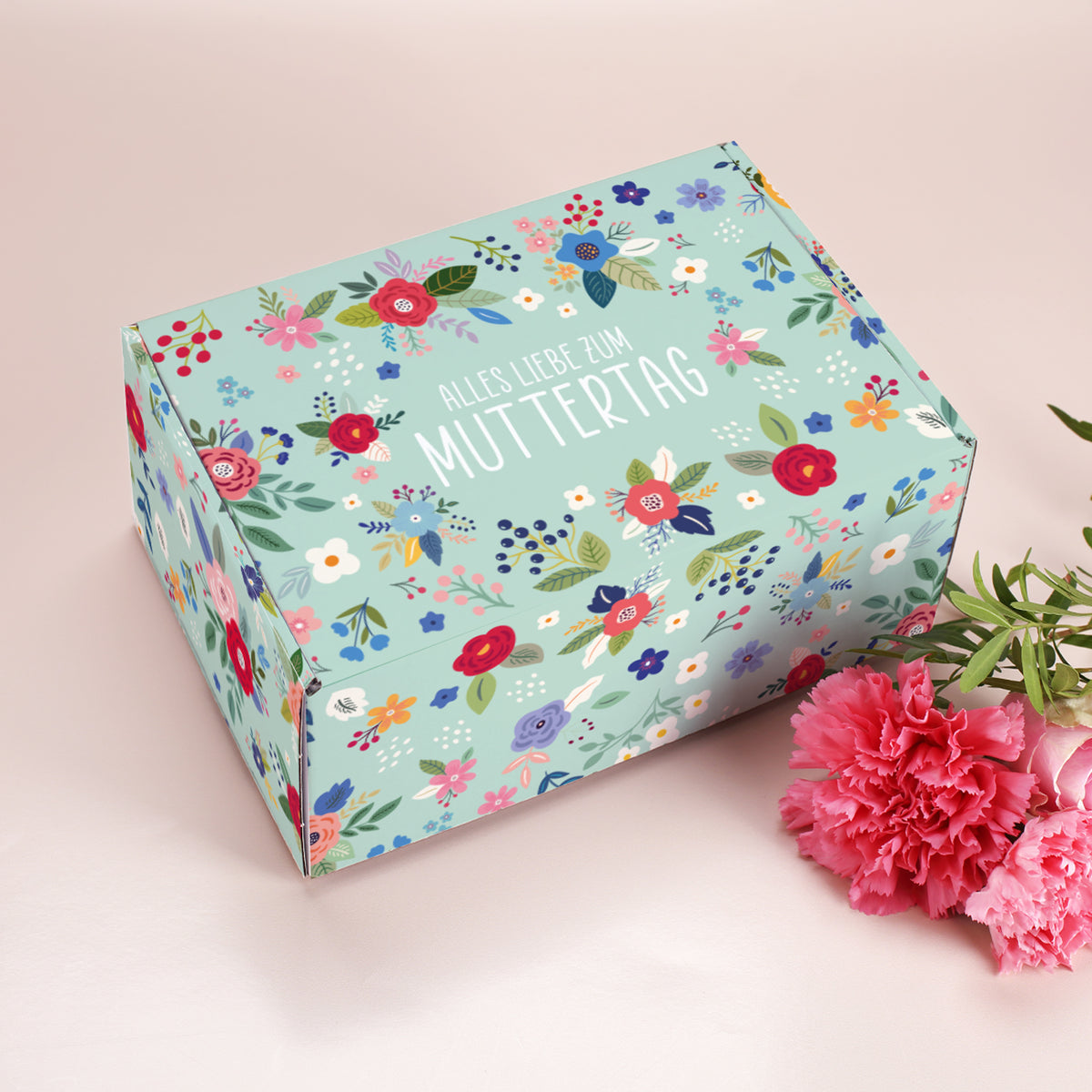Geschenkverpackung zum Muttertag im floralen Look, rechteckig mit Aufdruck Alles Liebe zum Muttertag und rosa Nelken als Dekoration