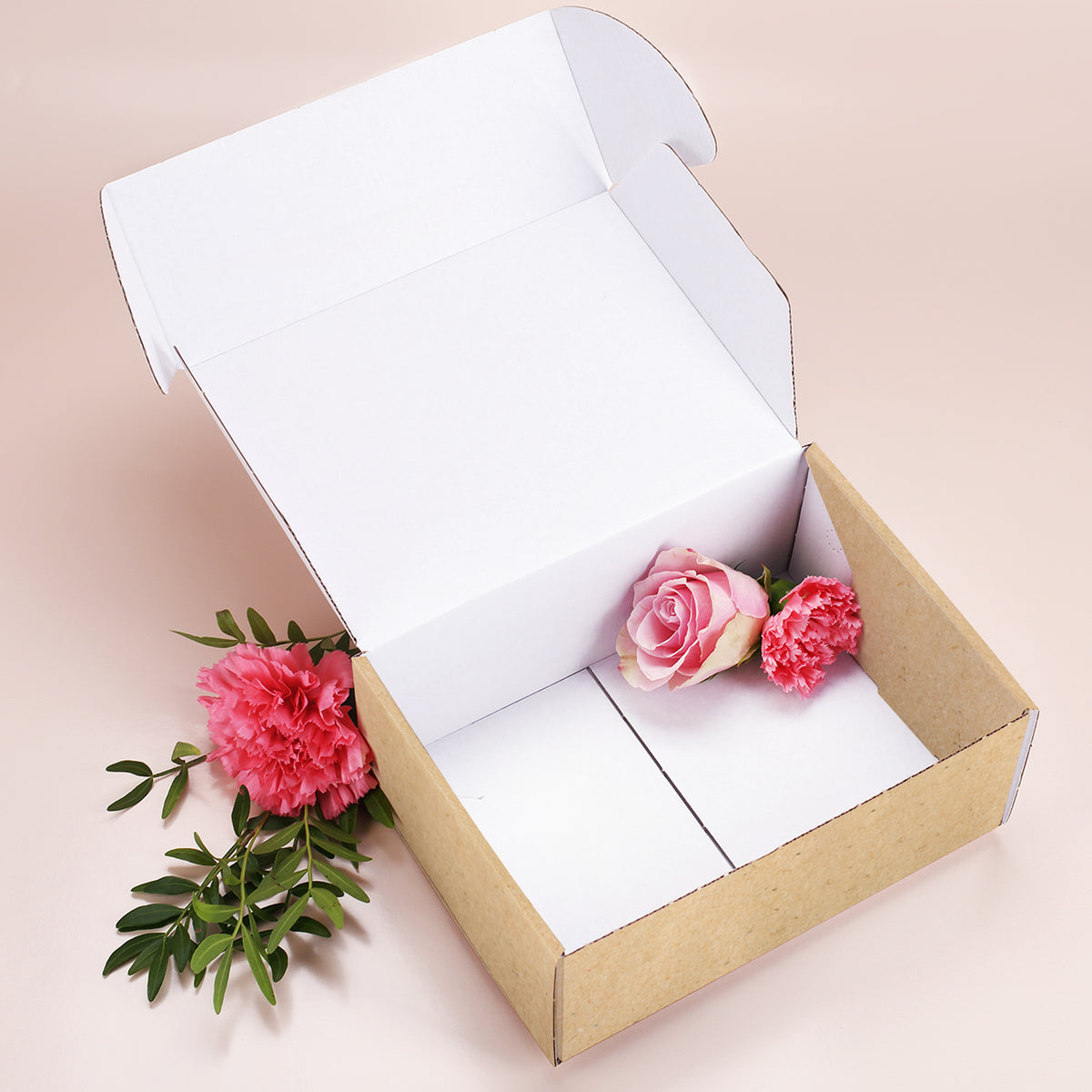 Geöffnete Geschenkbox in Kraftpapier-Optik, innen weiß, befüllt mit Rosen – ideal für größere Präsente