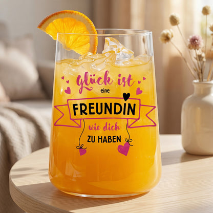 Trinkglas mit orangefarbenem Saft, Eiswürfeln, Orangenscheibe und Spruchmotiv für die beste Freundin