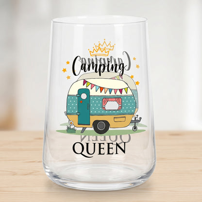 Leeres transparentes Trinkglas mit beidseitigem Camping Queen Motiv und Wohnwagen auf hellem Tisch