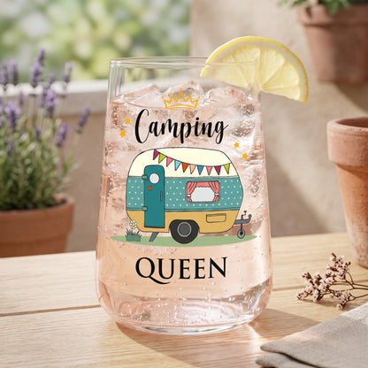Trinkglas mit rosa Getränk, Eiswürfeln und Camping Queen Wohnwagen-Motiv auf Terrasse