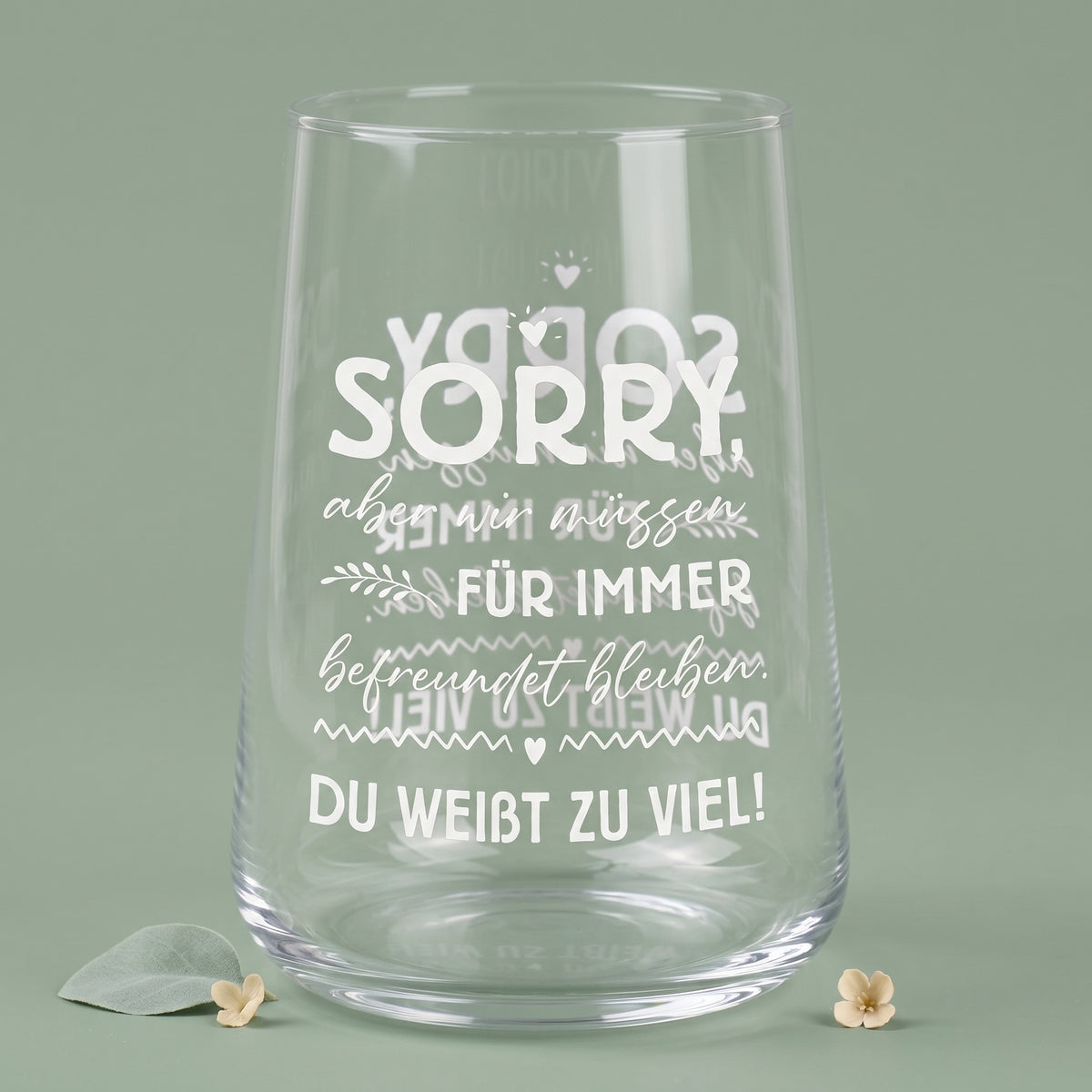Leeres transparentes Trinkglas mit weißem Motivdruck und sichtbarer Spiegelung des Spruchs