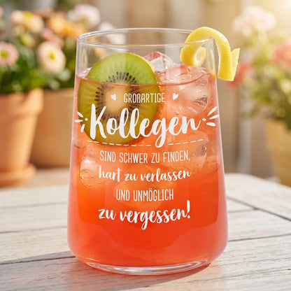 Trinkglas mit Kollegen Spruch, gefüllt mit pinkem Getränk, Eiswürfeln, Kiwi und Zitronenzeste