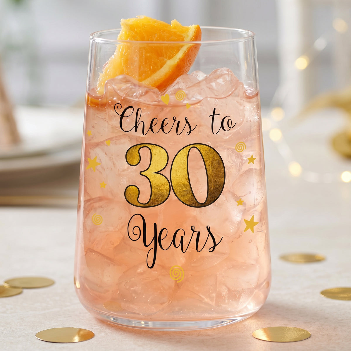 Cocktailglas zum 30. Geburtstag mit rosa Getränk, Eiswürfeln, Orangenscheibe und goldener 30