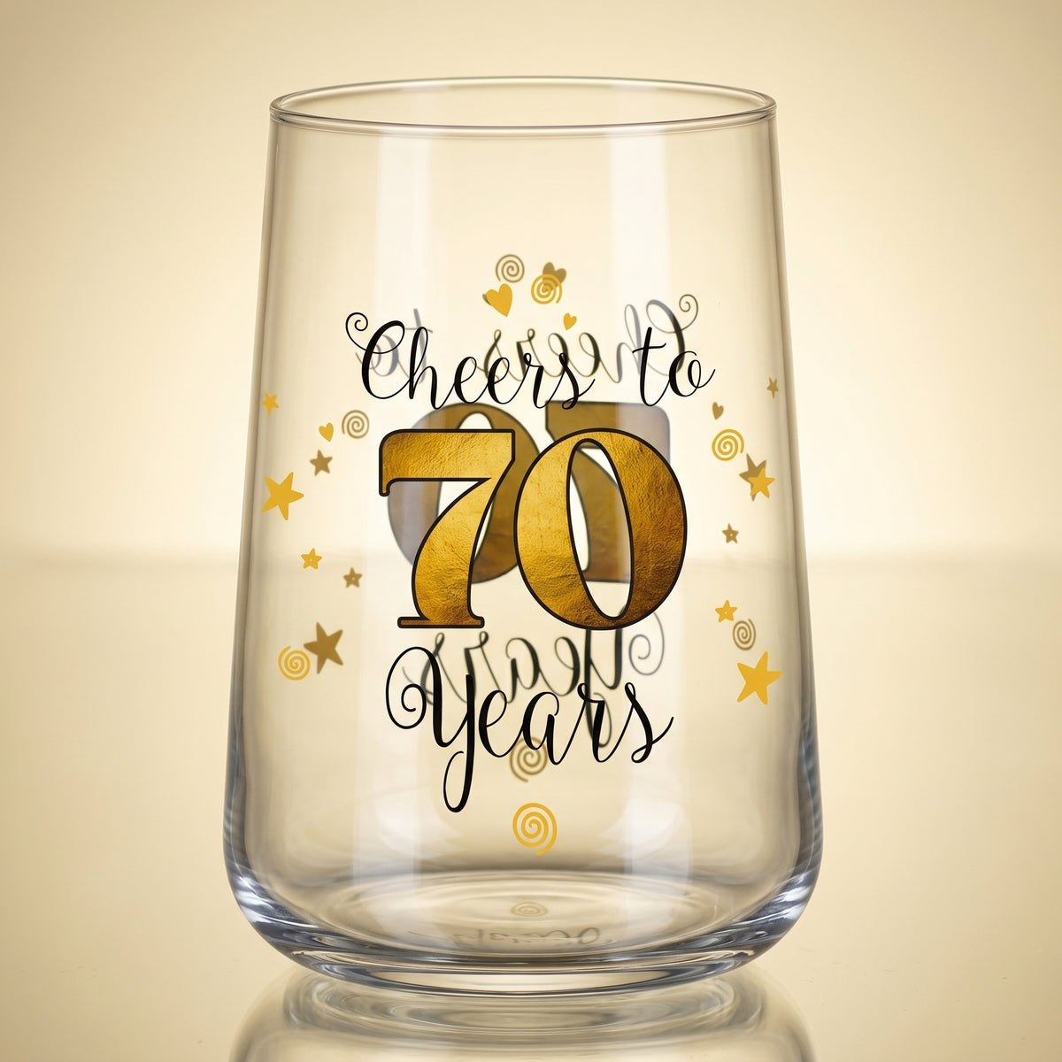 Leeres Trinkglas mit Cheers to 70 Years Aufdruck auf goldenem Hintergrund