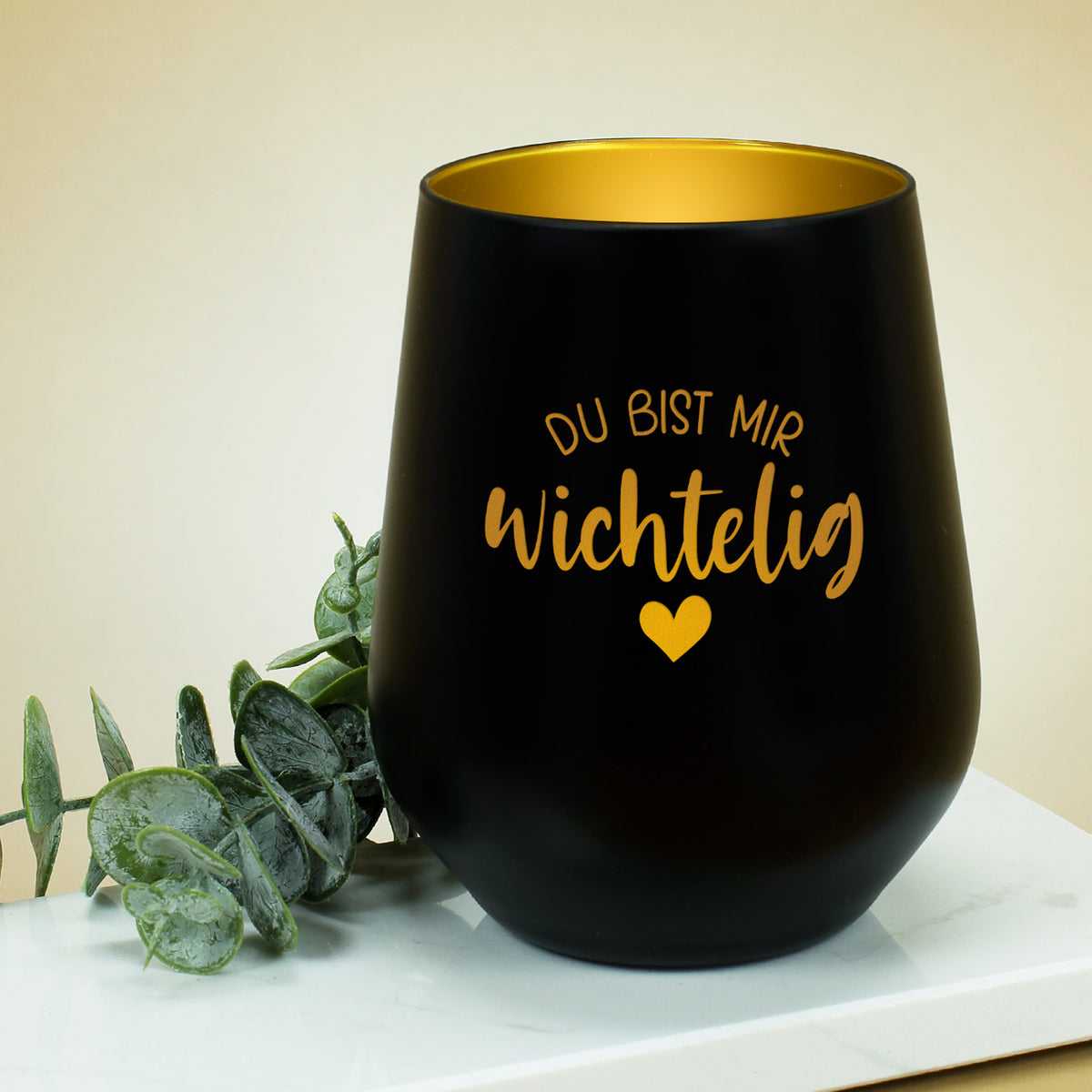 Schwarzes Wichtelig-Windlicht auf hellem Untergrund mit goldschimmernder Innenbeschichtung
