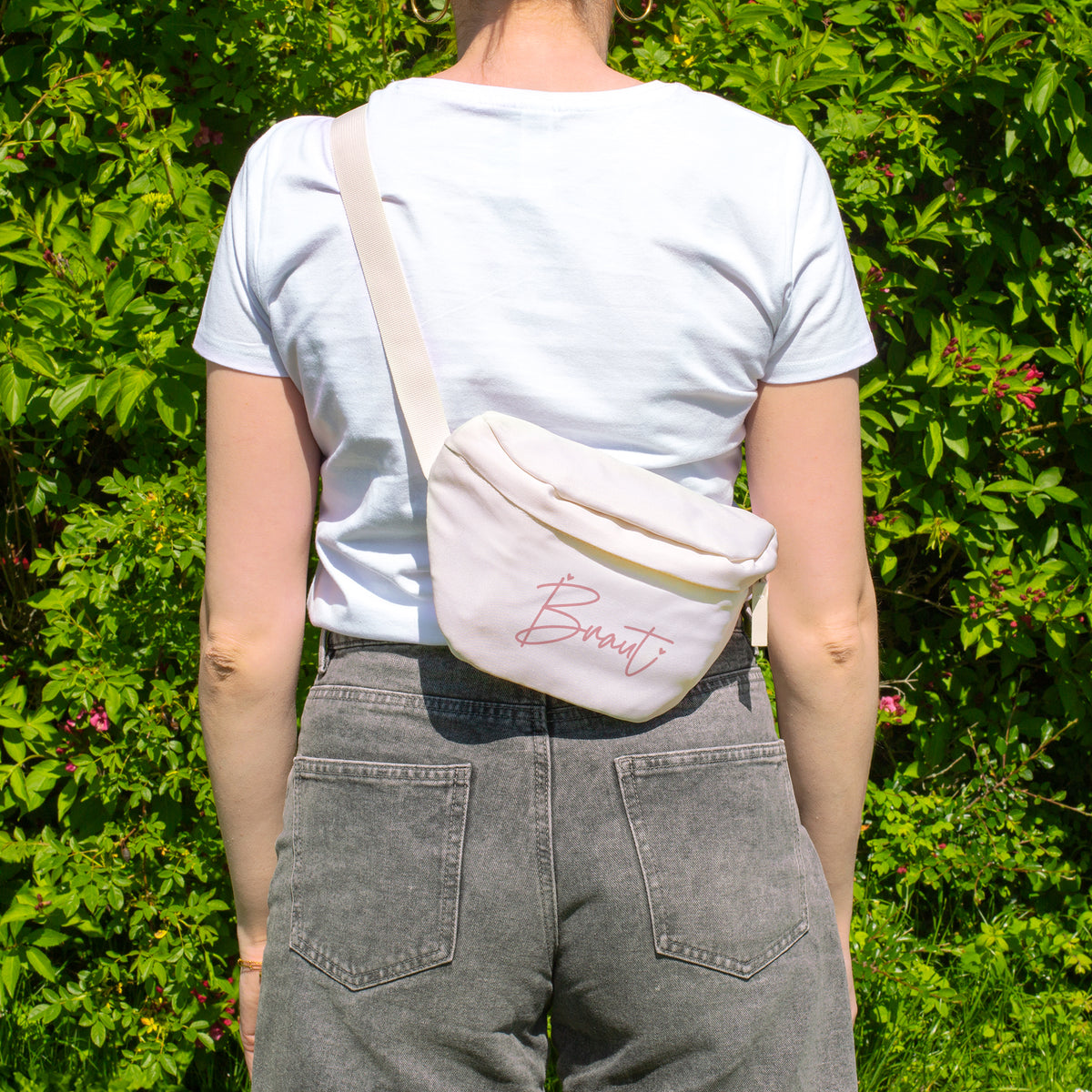 Cremefarbene Braut Bauchtasche als Crossbody Bag, getragen von hinten bei einem sommerlichen JGA-Outfit