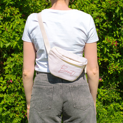 Cremefarbene Braut Bauchtasche als Crossbody Bag, getragen von hinten bei einem sommerlichen JGA-Outfit