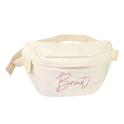 Cremefarbene Bauchtasche mit rosa Braut-Aufdruck als Produktbild auf weißem Hintergrund
