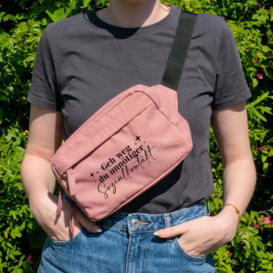 Rosa Bauchtasche mit Spruch Geh weg du unnötiger Sozialkontakt als Crossbody Bag getragen