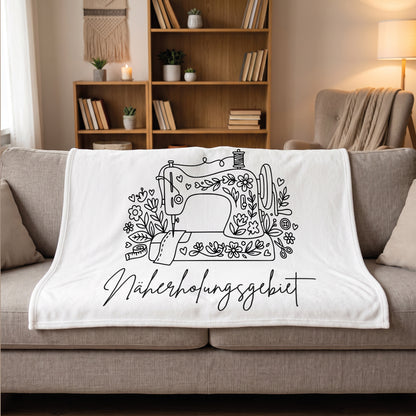 Kuscheldecke für Frauen und Nähfans mit Nähmaschinen Motiv auf dem Sofa